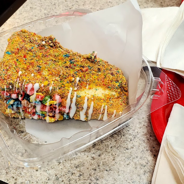 Fruity Pebbles cheesecake, a creamy slice crusted and topped with bright fruity cereal
